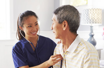 caregiver checking the heart rate of senior man